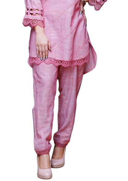 Person wearing a pink outfit with lace details in a room.